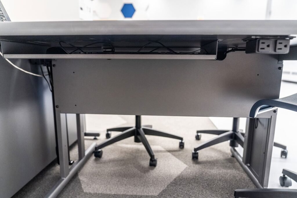 Close-up view of custom keyboard storage bay and Mini-Tap Power Interface installed on Computer Comforts' Collaborative Student Table.